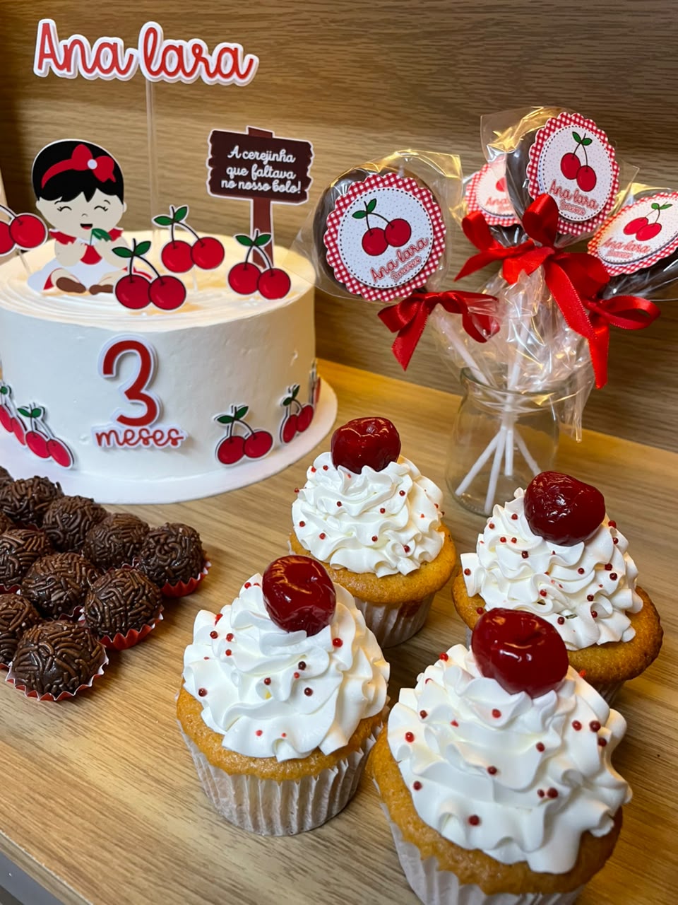 Mesa de festa tema cerejinha com bolo e cupcakes